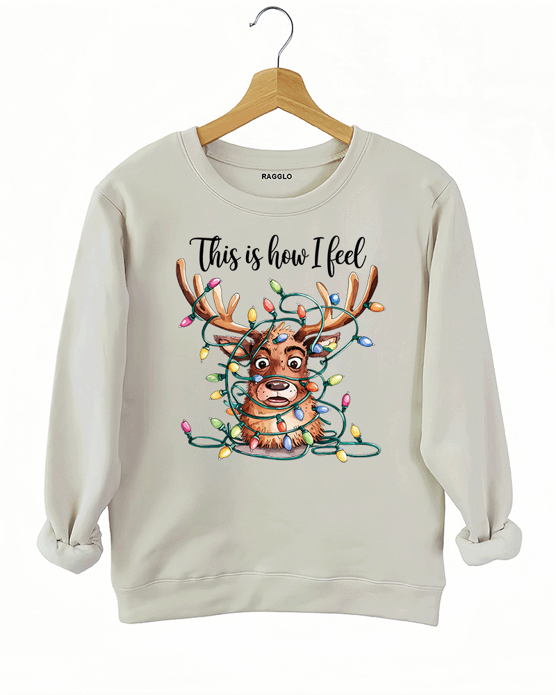 Beige sweatshirt with a graphic of a reindeer entangled in holiday lights, alongside the text 'This is how I feel,' available on Ragglo.