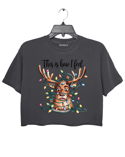 Dark gray crop top featuring a cartoon reindeer tangled in colorful Christmas lights with a humorous expression, accompanied by the text 'This is how I feel,' available on Ragglo.