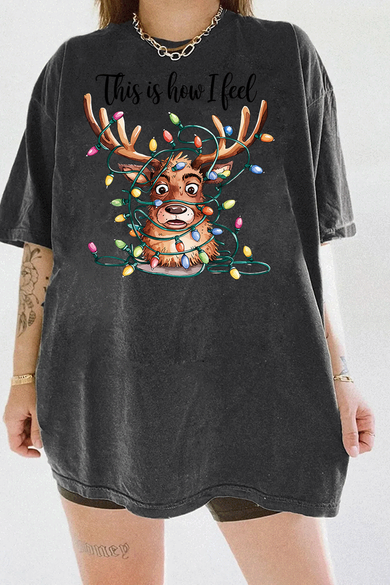 Dark gray T-shirt displaying a reindeer with tangled Christmas lights around its antlers, paired with the humorous text 'This is how I feel,' available on Ragglo.