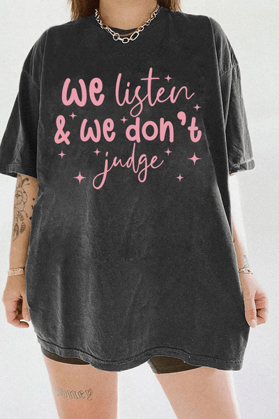 A dark gray t-shirt from Ragglo with the text "We listen & we don't judge" in pink, decorated with star accents.