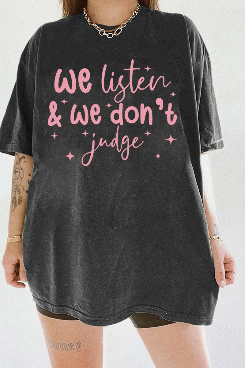 A dark gray t-shirt from Ragglo with the text "We listen & we don't judge" in pink, decorated with star accents.