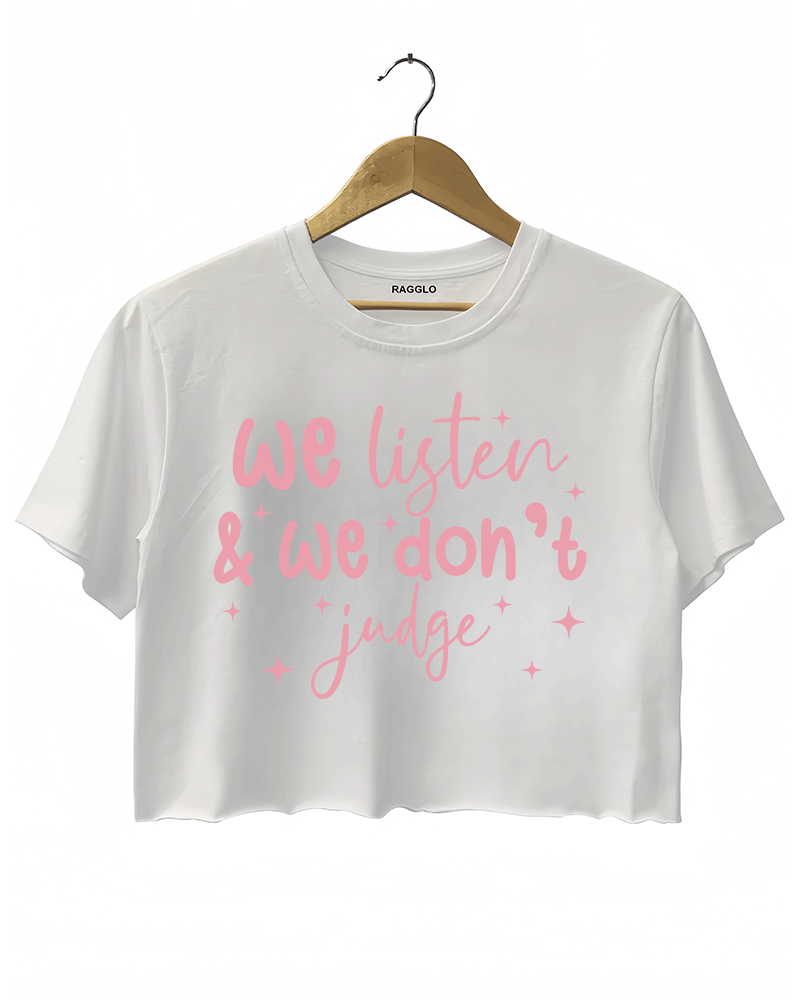 A white cropped t-shirt from Ragglo with the text "We listen & we don't judge" in pink, decorated with star accents.