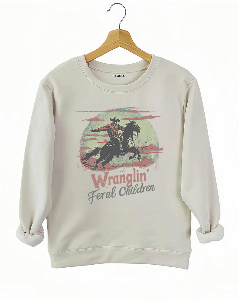 Ragglo beige sweatshirt featuring a western-themed cowboy on horseback with the text 'Wranglin' Feral Children,' in a vintage design style with dusty desert tones.