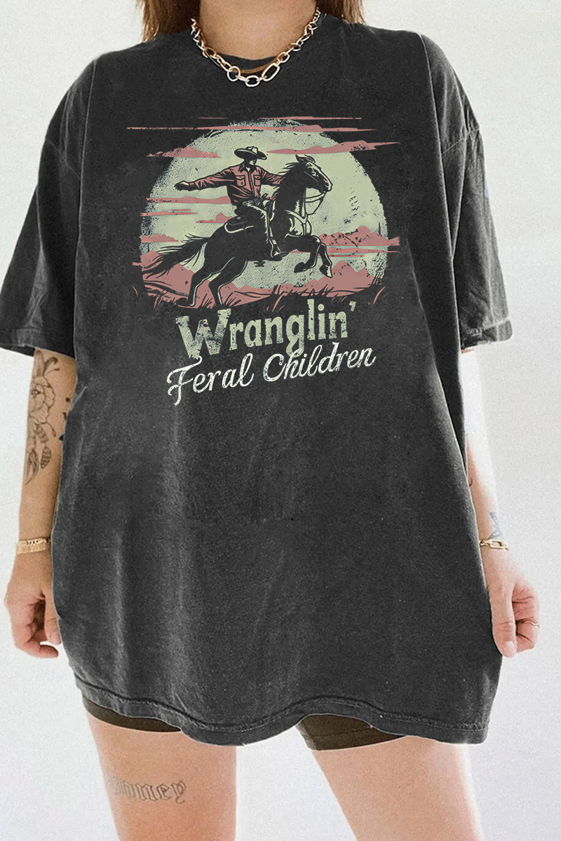 Ragglo dark gray T-shirt with a vintage cowboy design, highlighting a cowboy on horseback with the text 'Wranglin' Feral Children' set against a desert backdrop.