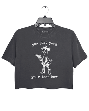 You Just Yee’d Your Last Haw graphic featuring a cowboy duck with a revolver, bringing a humorous western theme on a dark gray crop top, available on Ragglo.