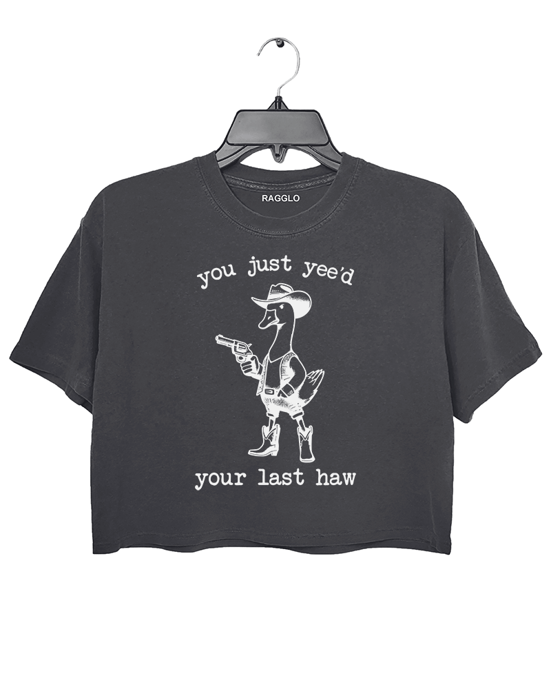 You Just Yee’d Your Last Haw graphic featuring a cowboy duck with a revolver, bringing a humorous western theme on a dark gray crop top, available on Ragglo.