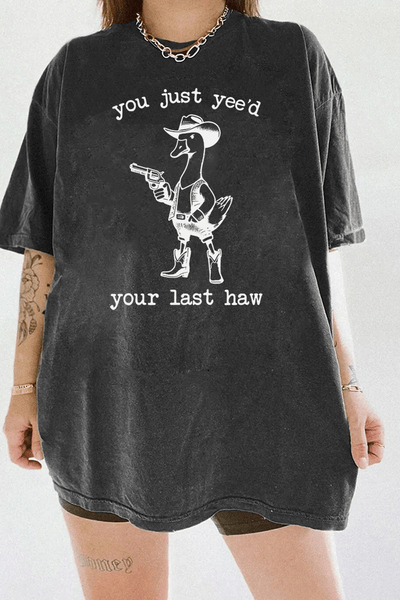 Humorous western duck graphic with a cowboy theme and the text 'You Just Yee’d Your Last Haw' on a dark gray T-shirt, available on Ragglo.