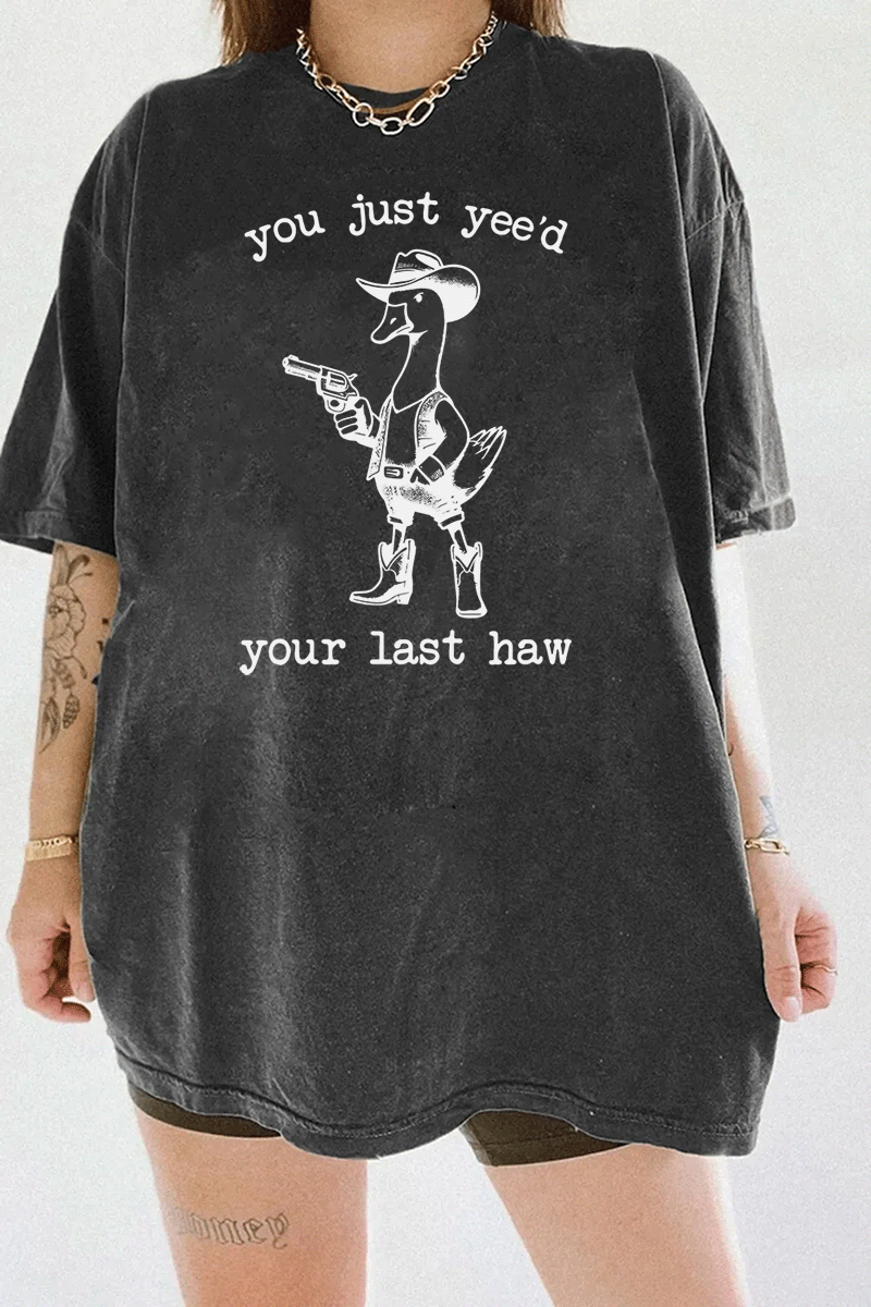 Humorous western duck graphic with a cowboy theme and the text 'You Just Yee’d Your Last Haw' on a dark gray T-shirt, available on Ragglo.