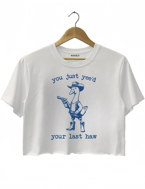Funny western-themed design with a duck dressed as a cowboy and the text 'You Just Yee’d Your Last Haw' on a white crop top, available on Ragglo.