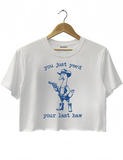 Funny western-themed design with a duck dressed as a cowboy and the text 'You Just Yee’d Your Last Haw' on a white crop top, available on Ragglo.